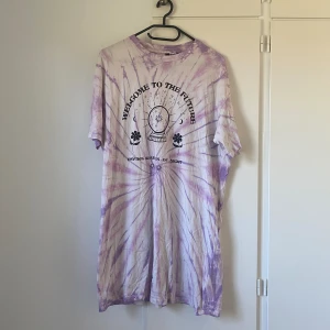 T-shirtklänning - En klänning i form av tshirt med fint mönster och tryck. Perfekt att ha över bikini exempelvis. Knappt använd! 