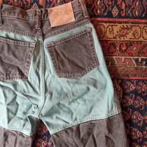 Coola vida jeans med unika detaljer!  Litet lagat hål på ena knät  Midja: 33 cm  Innerbenslängd: 89 cm
