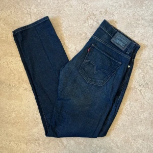 Levis 511 Mörk Blåa Jeans - Levis jeans i modellen 511, använda men i gott skick. Storlek: 33 W, 34 L, Midja: 44 cm Ytterben: 112 cm Benöppning: 18.5 cm