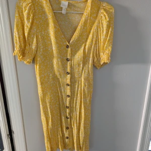 Gul blommig sommarklänning  - Tunn gul blommig sommarklänning från H&M använd fåtal gånger. Mycket bra skick.