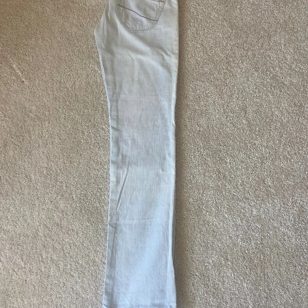 Ett par vita/väldigt ljusblåa lågmidjade jeans från Lee. Har lite fläckar men inget som märks av.  Midjemått: 41 cm Ytterbenslängd: 102 cm Innerbenslängd: 84 cm. Jeans & Byxor.