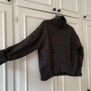 Mörkgrå polotröja - Mörkgrå, smått melerad, tröja från H&M. Polokrage och väldigt fin form på tröjan! 