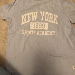 Blå t-shirt  - Säljer en blå t-shirt med text på. 