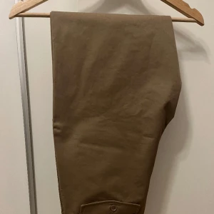 Filippa K M Flynn chinos (STL 48) - Filippa K M Flynn chinos (STL 48). Färg: Dark Khaki. Nyskick, endast använda en gång, säljes p.g.a. fel storlek. Nypris: 1500kr.