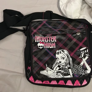 Monster high väska  -  Monster high väska  den ser nästan som ny ut och ser inte ut och vara använd förutom att dragkedjan på framsidan har gått lite sönder som man ser på andra bilden 