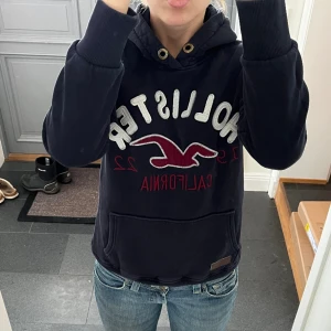 Mörkblå hoodie från Hollister - Mörkblå hoodie från Hollister i fint skick. Storlek M men väldigt liten i storleken så skulle säga XS/S. Jag brukar ha S/M så den är lite liten på mig. Använd gärna köp nu!