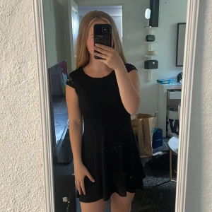 Kläning  - En svart kläning med en dragkedja på ryggen 