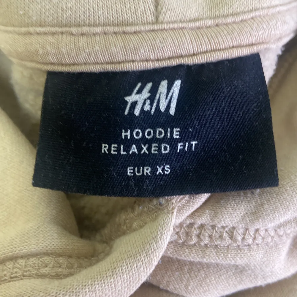 En bekväm beige hoodie från H&M i storlek XS. Hoodien har en avslappnad passform med en huva och långa ärmar. Perfekt för vardagsbruk.. Hoodies.