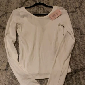 Vit nelly tröja  - En vit nelly tröja med lite öppen rygg, Har aldrig använt för den är lite för stor för mig, Prislappen är kvar skriv privat så kan vi prata om pris❤️
