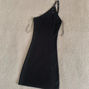 ZARA ribbad mini klänning one shoulder med spänne - Otroligt snygg ribbstickad klänning från ZARA med silvrigt spänne på ena axeln. Aldrig använd, har råkat slita av prislappen. I nyskick, utan anmärkningar. Supersnygg! 🌷