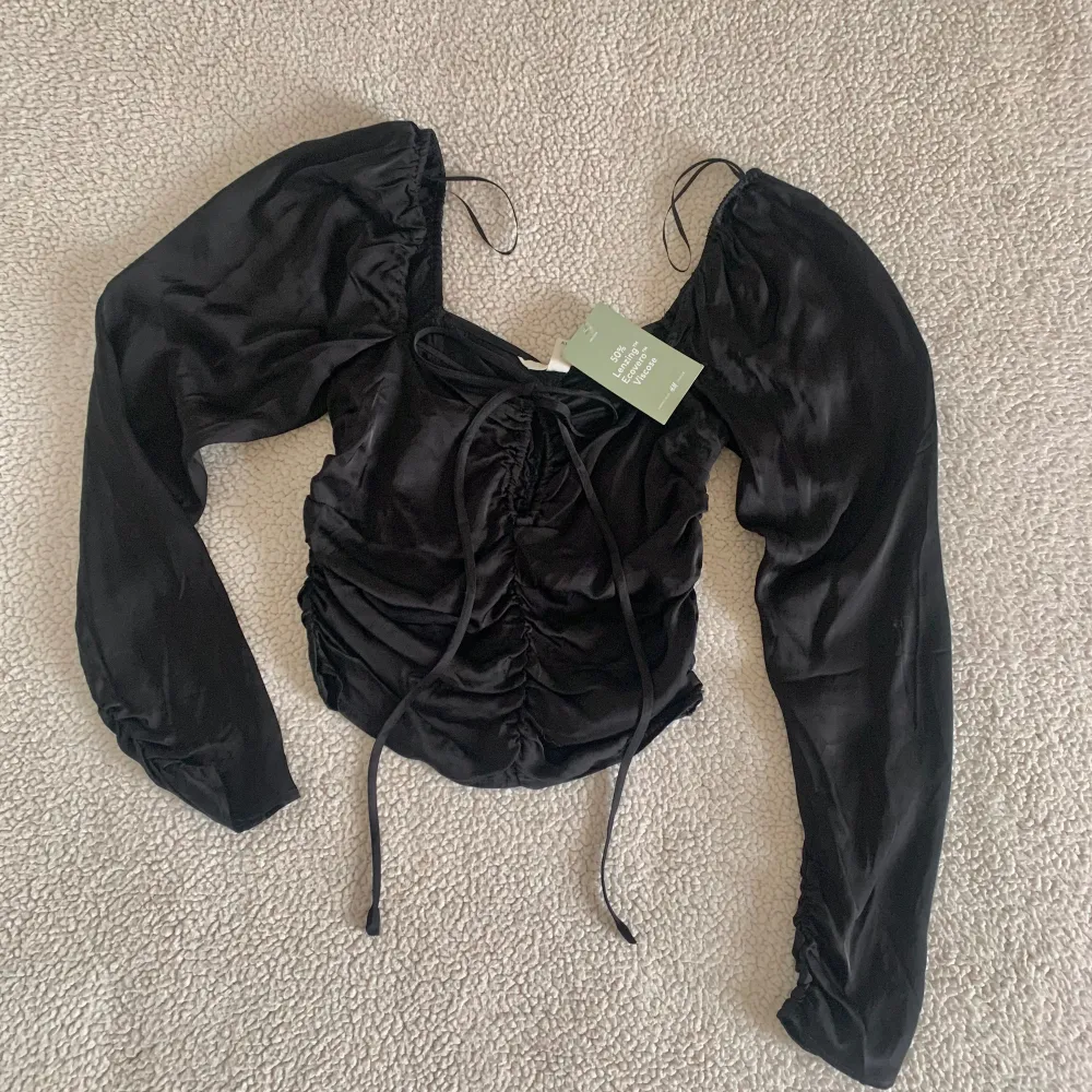 Svart croptop från H&M med dold dragkedja på sidan. Ny med tags kvar, utan anmärkningar.. Toppar.