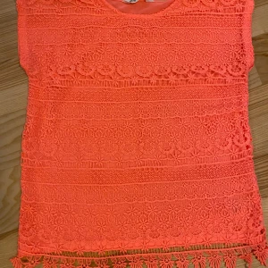 Topp strl 134/140 - Korallfärgad topp i Fint skick.  Kolla gärna in mina andra annonser för samfrakt. Katt finns i hemmet (allergivänlig ras).