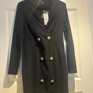 Blazer klänning  - Blazer klänning med guldiga knappar. Oanvänd med taggar kvar. Nypris 229kr.