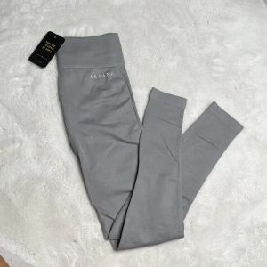 Träningstights  - Grå träningstights i modellen ”EVE seamless” från Astaniwear Oanvända, endast ett litet fel i sömmen (se bild 4)  Strl: S