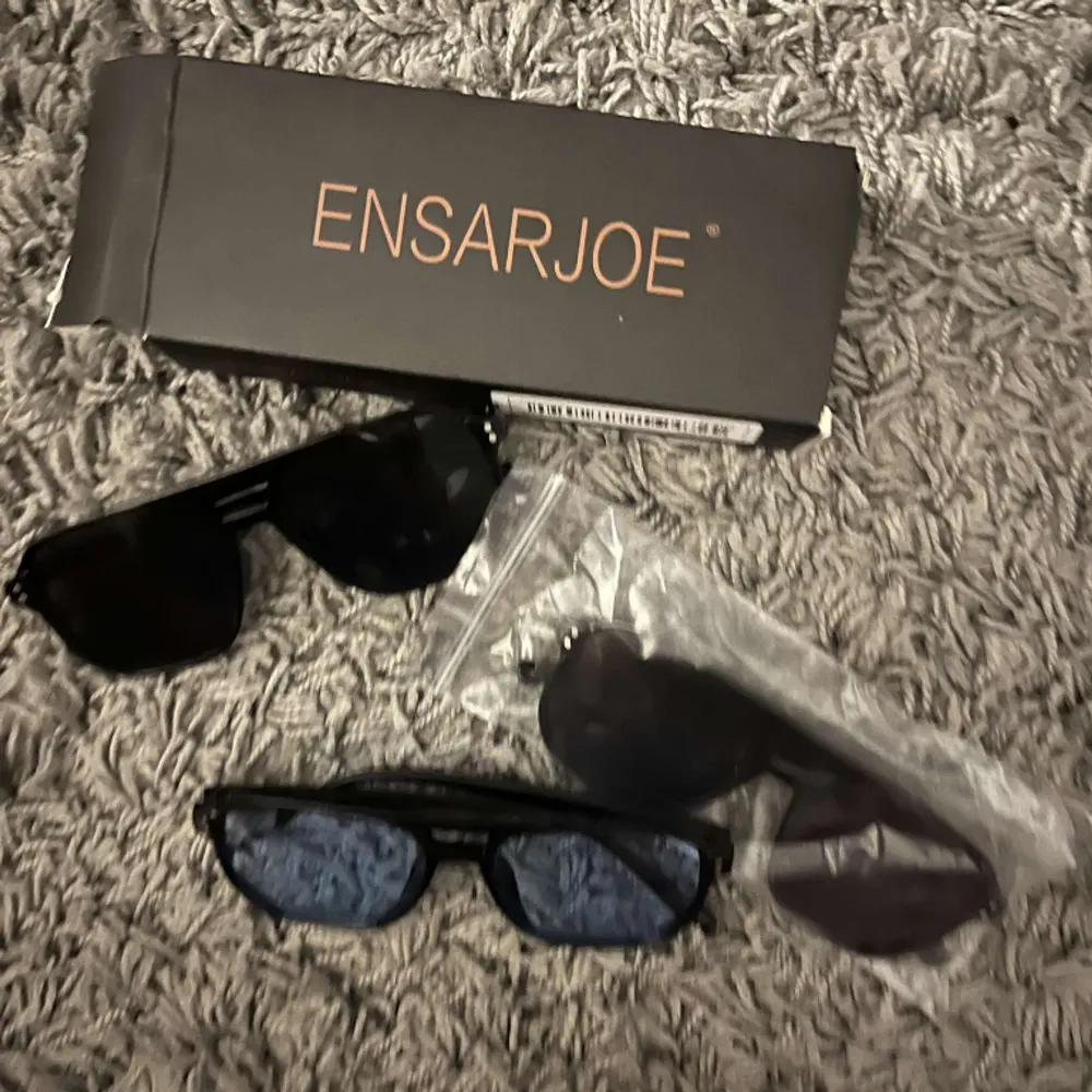 Solglasögon från Ensaroje, 1par glasögon med svart glad och ett par med blåa glasögon. Förpackning och tvätt till glaset medföljer. Alla är helt oanvända. Alla för 300 eller 150kr styck  . Accessoarer.