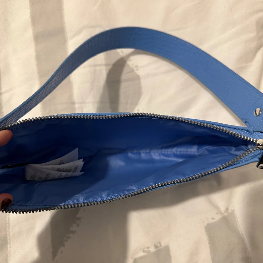 En väska från H&m i en jättefin blå färg, jättefin till sommaren. Aldrig använd så fint skick. . Väskor.