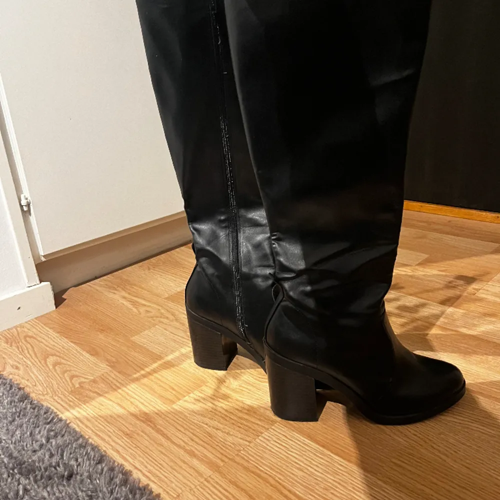 Svarta knähöga boots som endast är använda ett fåtal gånger. Dom är knähöga i ett lädermaterial(fake) i storlek 38 men passar perfekt på mig som är storlek 37. Skor.