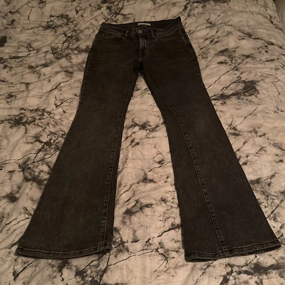 Mörkgråa bootcut jeans från Gina använda flertal gånger så lite slit i byxkanten längst ner pga för långa och lite slit på fickorna dm för fler bilder säljer pga för små . Jeans & Byxor.