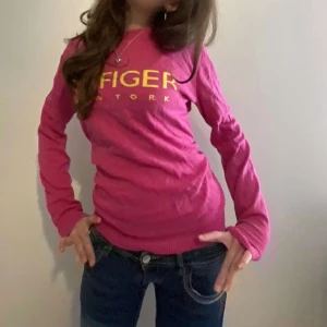 Rosa Tommy Hilfiger tröja - Säljer denna super varma o snygga Tommy Hilfiger tröjan😍 Säljs då den inte längre kommer till användning💕 Är storlek XL(barn) så passar S-M skulle jag säga På tröjan står de i gul text ”HILFIGER NEW YORK”
