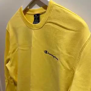 En gul baggy ganska avslappnad sweatshirt från Champion. Tillverkad av 79% bomull och 21% polyester. Hög kvalité och inga förslitningar. 