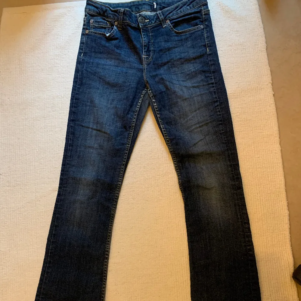 Mörkblå, lågmidjade, utsvängda jeans. Jag vet inte riktigt vilket märke eller storlek, då lappen är bortklippt. Jag uppskattar dock att de är typ storlek 36 för att de passar mig som vanligtvis bär 36.. Farkut & Housut.