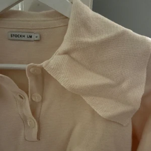 Tröja  - Finsstickad tröja i beige med fina detaljer. 