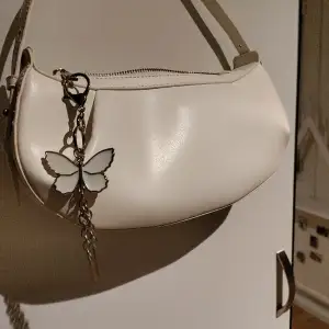 Supersöt väska med en fjäril i dragkedjan🥰 nypris 400 kronor, oanvänd och justerbart axelband ❤️