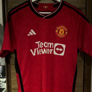 Manchester United 23/24 Hemmaställ - Äkta Manchester United tröja säljs eftersom den är lite för stor då den köptes i USA och är därmed en lite större M. Bara använda ett par gånger och är i samma skick som när den köptes. Bara att skriva om du har några frågor!