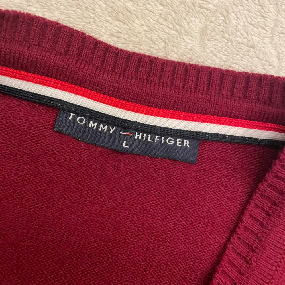 Jätte fin röd Tommy Hilfiger som är i nytt skick! Den är i storlek L men den är mindre än det skulle säga att den är i storlek S/M. Tröjor & Koftor.