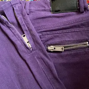 Jättecoola lila jeans från ”Madeleine” med snygga dragkedjedetaljer. Säljer då de är för små för mig, inga skador eller defekter.  Mått tvärs över midjan: 36cm Innerbenslängd: 76cm Längd på hela byxan 99 cm  Skriv vid frågor!! ❤️💋