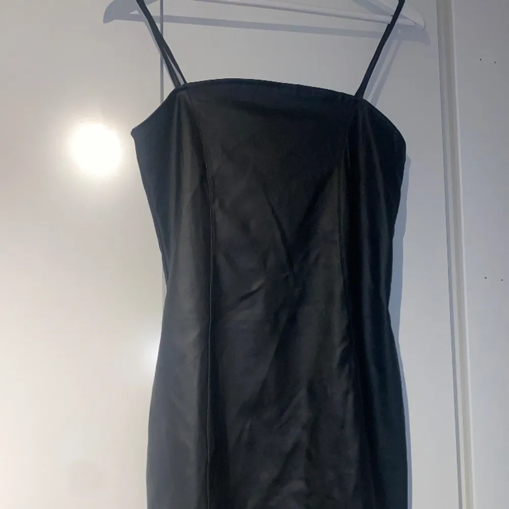 Kort svart klänning från H&M. Läder- liknande material. Endast använd en gång. Jättefint skick. Strl M, men passar nog en S✨. Klänningar.