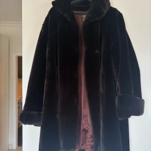 Pälskappa - Såå fin mörkbrun pälskappa från Creation aniral Paris. Storlek är lite oklart men den sitter lite oversized på mig som är 163 cm och går ungefär till knäna. Använd endast enstaka gång. Den tredje knappen, längst ner har försvunnit. (Inte äkta päls).