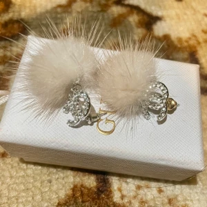 Chanel öronhängen vit pälsboll med strass logga - Snygga Chanel öronhängen med strass och vit pälsboll