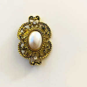 Vintage brosch  - Vacker brosch i guldfärgad metall  Okänt material 