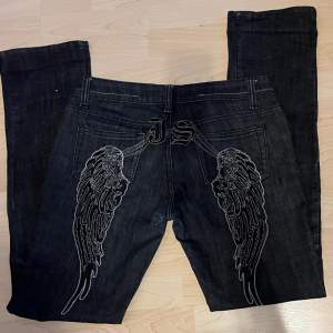 Mörka raka jeans med broderade vingar på baksidan av byxorna! ⭐️ Byxorna är helt oanvända & är precis som nya!  -Midjemått rakt över = 44cm -innerbenslängd= 84cm -längd på hela= 106cm 