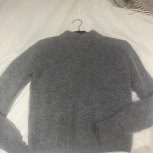 Tröja - Långärmad grå tröja med vaddar vid axlarna. Lurvig. Köpt på Hm i Köpenhamn. Använd en gång. Mohair/wool blandning.