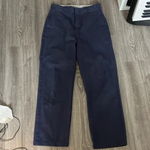 Mörkblå Dickies - Ett par snygga mörkblå Dickies i perfekt skick. De är i storlek w28, själv är jag 161 cm och de går lite nedanför hälen vilket enligt mig är perfekt. Skriv för fler bilder! 