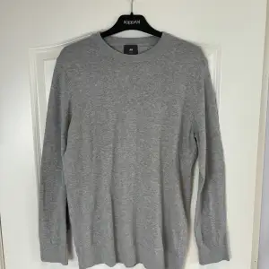 En grå stickad tröja i storlek M. Använd ett fåtal gånger men är i väldigt fint skick!