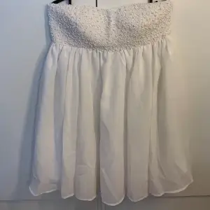 Super söt vit klänning med pärlor upptill som är perfekt till studenten. Aldrig använd så i super fint skick⭐️  (Kan skicka mer information vid önskemål)