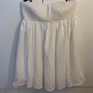 Studenklänning  - Super söt vit klänning med pärlor upptill som är perfekt till studenten. Aldrig använd så i super fint skick⭐️  (Kan skicka mer information vid önskemål)