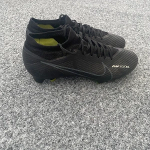 Nike air zoom mercurial vapor 15 FG Black/yellow - Nike fotbollsskor i storlek 39. De är andvända i en säsong. Skick 10/10 ser ut som nya, ej slitna.