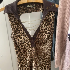 Mcbling y2k leopard linne - Glittrigt leopard piké/linne med rhinestones och öppen rygg med snörning. Skitsnygg y2k vintage från märket ”monella vagabonda $nob”  som jag köpt second hand.