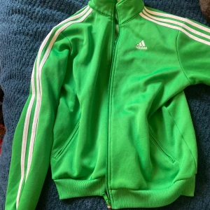 Grön Adidas hoodie  - Jag säljer min gröna adidas tröja då den inte andvänds, den e jättefin och skön!