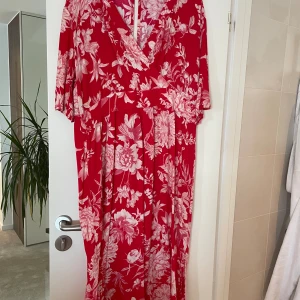 Röd maxi klänning  - Super fin röd långklänning med vita blommor. Maxi klänning.