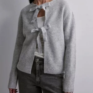 Kofta med rosetter - Stickad tröja med rosetter. Vändbar så rosetterna kan även vara i ryggen. Första bilden är lånad 