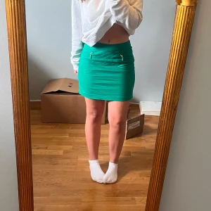 Grön minikjol - Fin grön kjol med guldragkejda