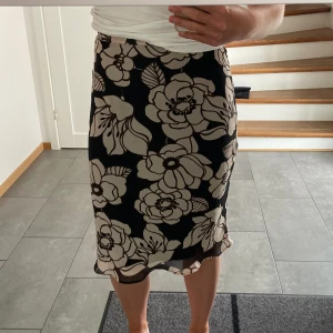 Blommig Kjol - En längre blommig kjol med volang längst ner i bra skick