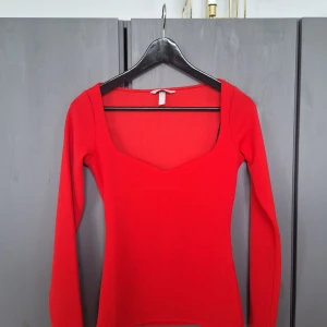 H&M oanvänd röd topp med hjärtformad urringning strl XS  - H&M oanvänd röd topp med hjärtformad urringning strl XS. Aldrig blivit använd, nyskick. Djurfritt och rökfritt. Missa inte mina andra annonser också ❤️