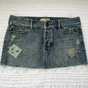 Jeanskjol med stenar  - Y2K jeanskjol med fina detaljer, går inte att få tag på längre!! Helt ny! Aldrig använd. Storlek 9 (27/28?). Midjemått 84cm, framsidans längd 28cm, baksidans längd 32cm. Tryck på ”köp nu” 💕