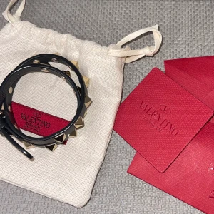 Valentino armband - Säljer mitt fina Valentino armband i modellen ”rockstud calfskin double-strap”.  Armbandet är mycket sparsamt använt, nästan nyskick.  Säljes med dustbag, tillhörande kort och extra nitar.  Köpare står för frakt, kan även hämtas i Göteborg.